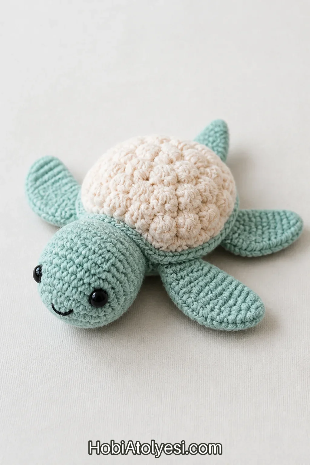 Tamamlanmış mini deniz kaplumbağası amigurumi temiz zeminde sergilenmiş