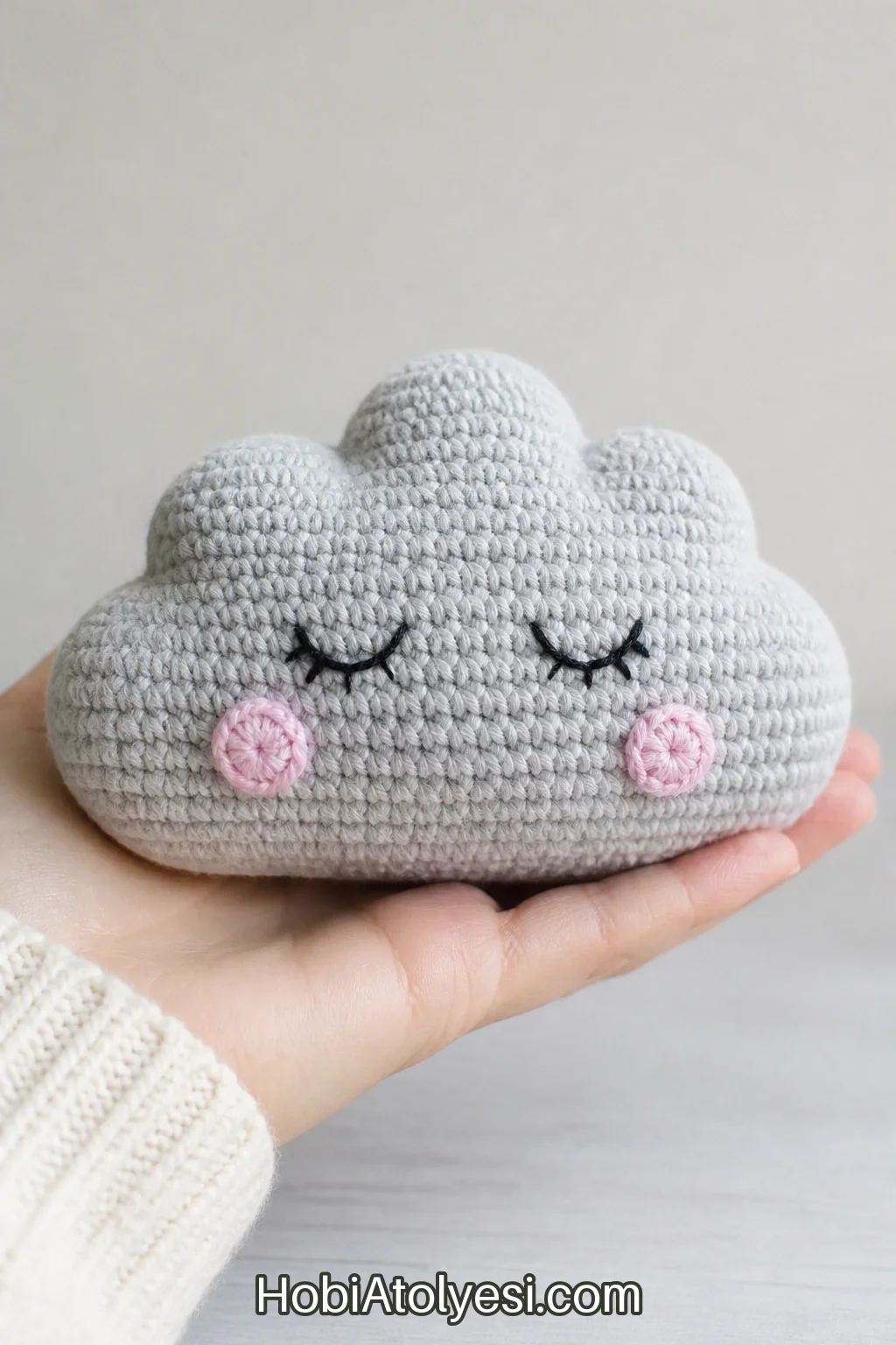 Bitmiş uyuyan bulut amigurumi yakın çekim; yumuşak form, nakış yüz ve humplar net şekilde görünüyor